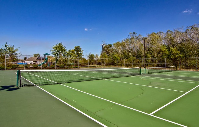 A tennis court with a net and trees in the background.