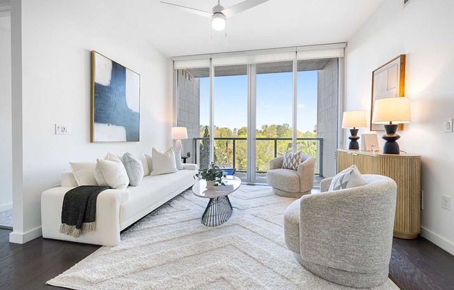 A living room with a white couch, a grey armchair, and a coffee table.