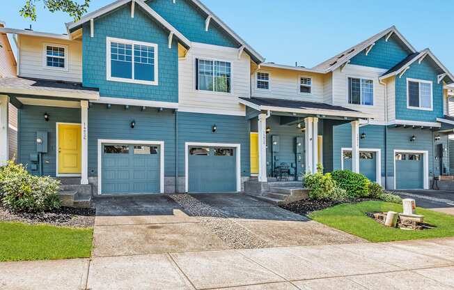 A row of townhomes with blue and yellow garage doors at The Landing Apartments and Townhomes, Oregon, 97045