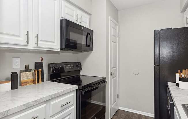 Model Kitchen with White Cabinets and Wood-Style Flooring at Grand Pavilion Apartments in Tampa, FL.