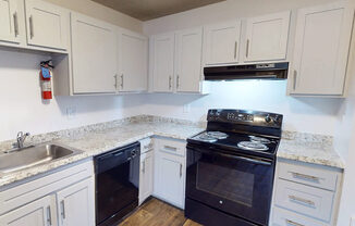 A kitchen with white cabinets and a black stove top oven.