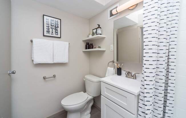 a white bathroom with a shower curtain and a toilet