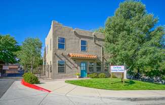 A building with a sign that says "Las Rivas" is in front of a tree.
