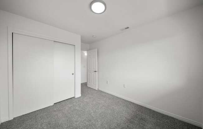 a bedroom with white walls and carpet