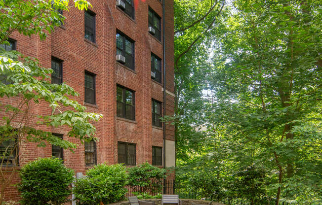 a courtyard with benches and a brick building