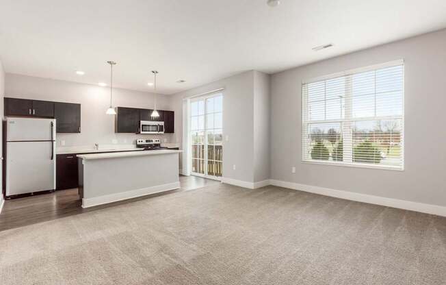 A spacious kitchen with a refrigerator, microwave, and oven.