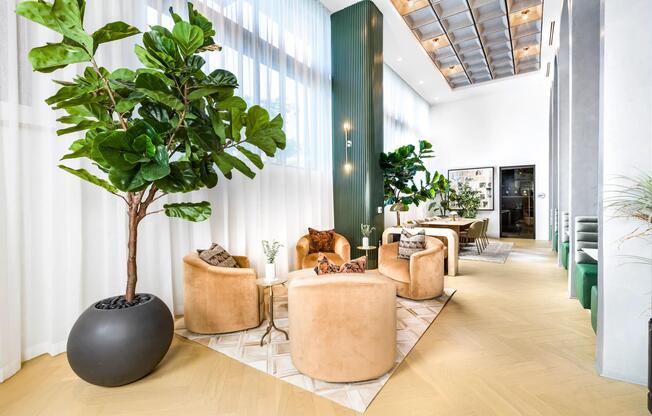 Resident seating area with sculptural chairs, tall ceilings, and natural light creating an inviting setting for coworking and quiet moments.