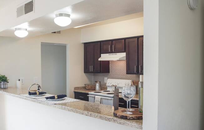 This is a photo of the breakfast bar and kitchen of the 991 square foot 2 bedroom, 2 bathroom apartment at The Biltmore Apartments in Dallas, TX.