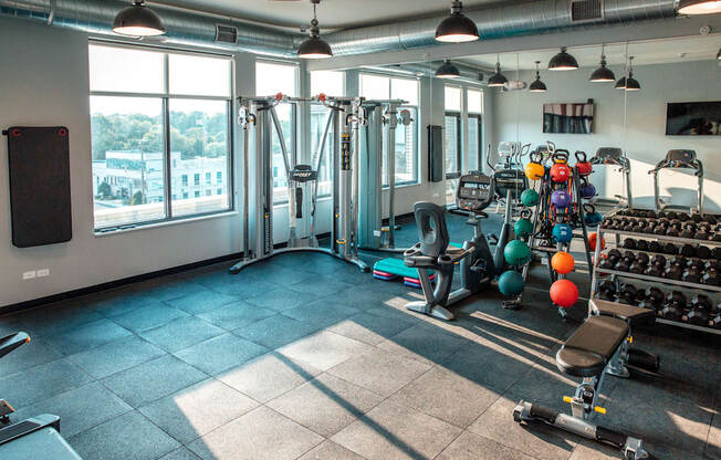 a gym with weights and other exercise equipment and windows at Barrington 101, Barrington, IL