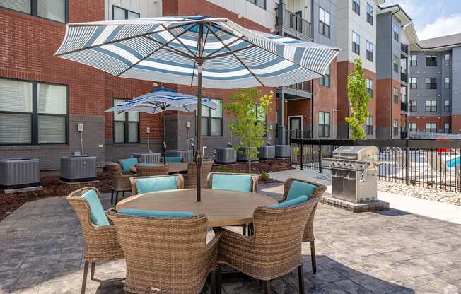 A patio with a table and chairs under an umbrella.
