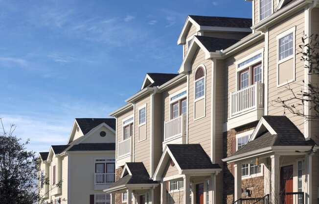 a row of townhomes on a sunny day with a blue sky