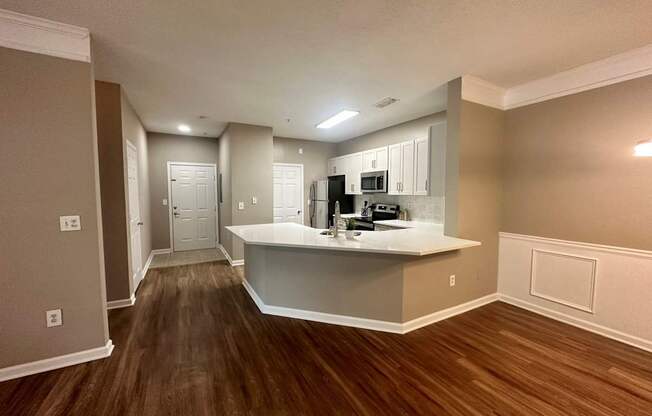 a kitchen and living room with hardwood floors