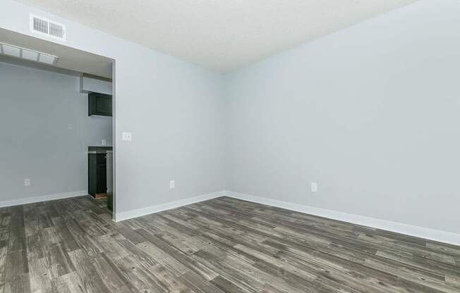 A room with a wooden floor and a white wall.