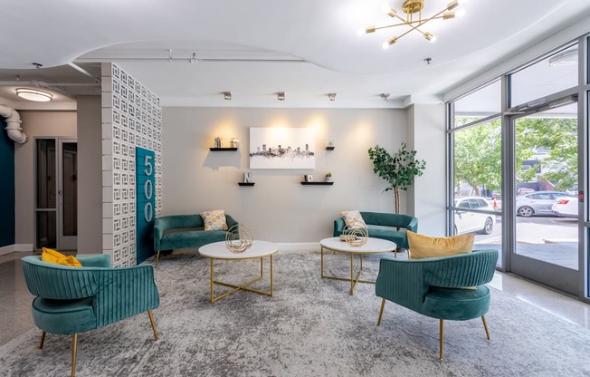 a lobby with chairs and tables and a large window