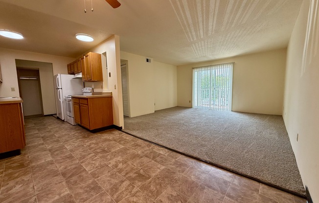 A room with a ceiling fan and a window with blinds.