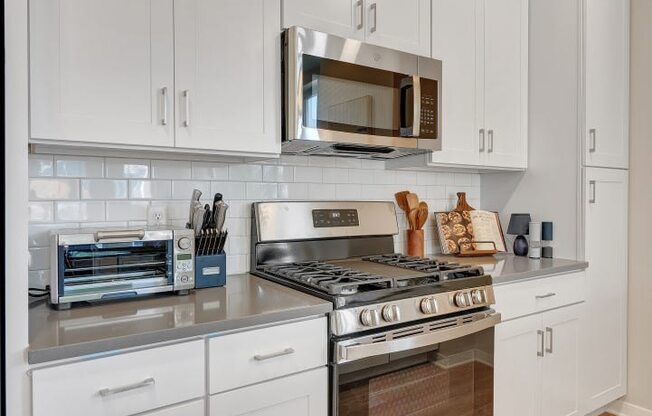 a kitchen with white cabinets and stainless steel appliances