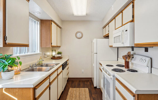a kitchen with white appliances and wooden cabinets