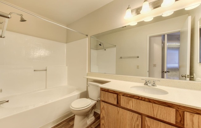 Vacant apartment home bathroom with sink and vanity and tub/shower combination. 