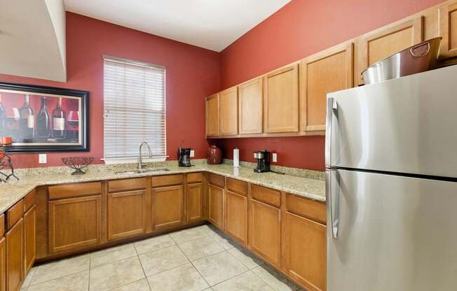 A kitchen with wooden cabinets and a stainless steel refrigerator.