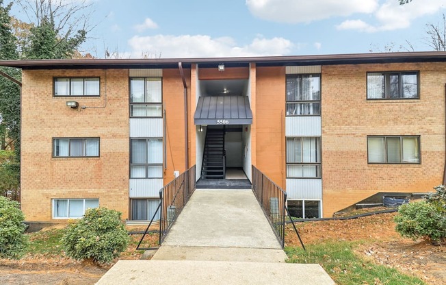 the front entrance of a brick apartment building