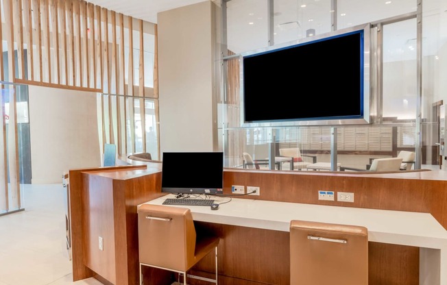 a desk with a computer and a monitor in a lobby