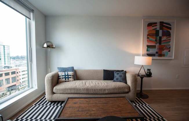a living room with a couch and a large window at Analog Tacoma, Tacoma, WA, 98402