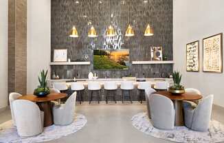 a dining room with white chairs and tables and a large mirror at Aura Vegas Apartments, Nevada