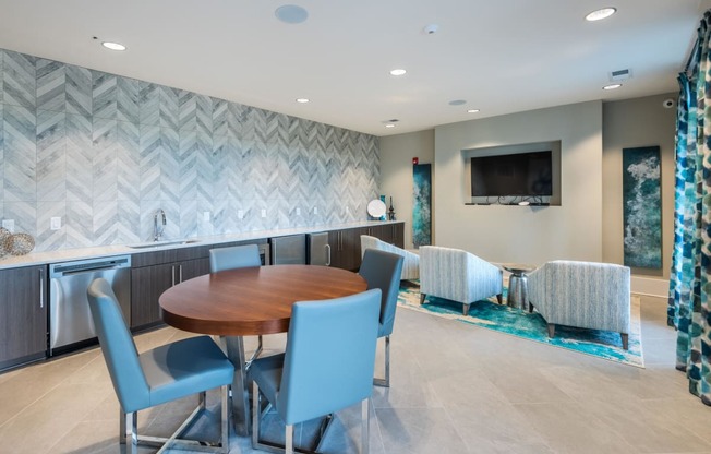 a dining room with a table and chairs and a kitchen with a tv