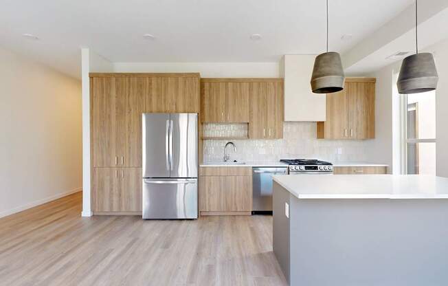 A modern kitchen with wooden cabinets and a white countertop at One West Drive Apartments, Excelsior, 55331