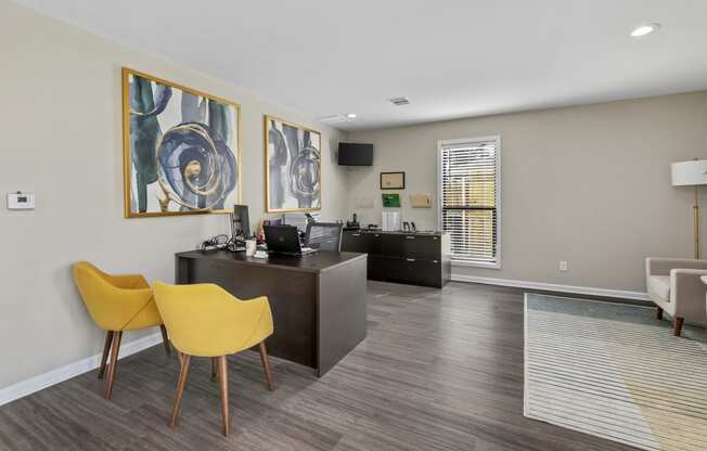 an office with yellow chairs and a desk and a window