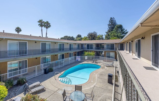 a pool is shown in the courtyard of a hotel