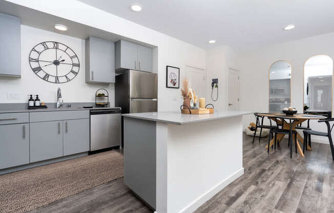 A modern kitchen with a large island and a dining table.