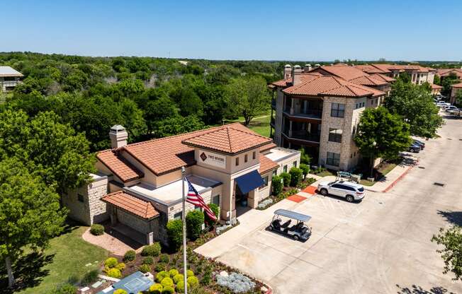 an aerial view of a building with cars parked in front of it