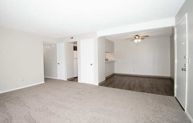 A room with a carpeted floor and a ceiling fan.