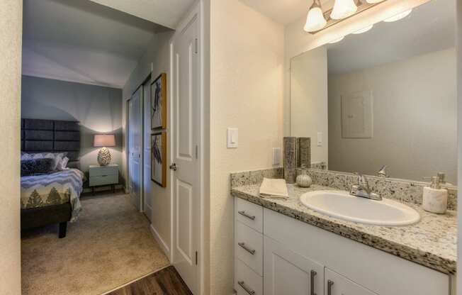 Bathroom with Adjoining Bedroom, White Cabinets and Vanity