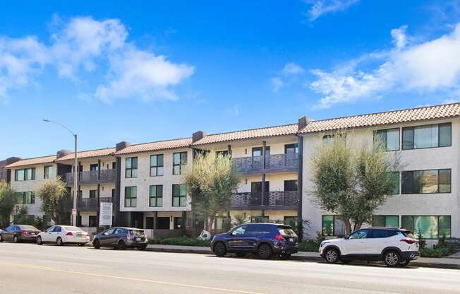 an apartment building on the side of a street with parked cars