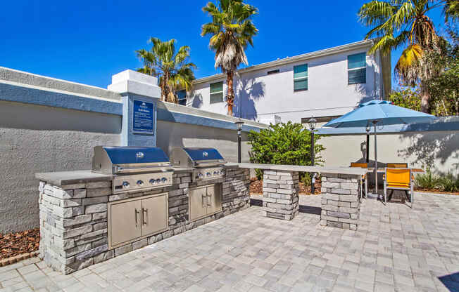 the outdoor patio has a barbecue grill and a table with umbrellas at Reserve at Temple Terrace, Temple Terrace