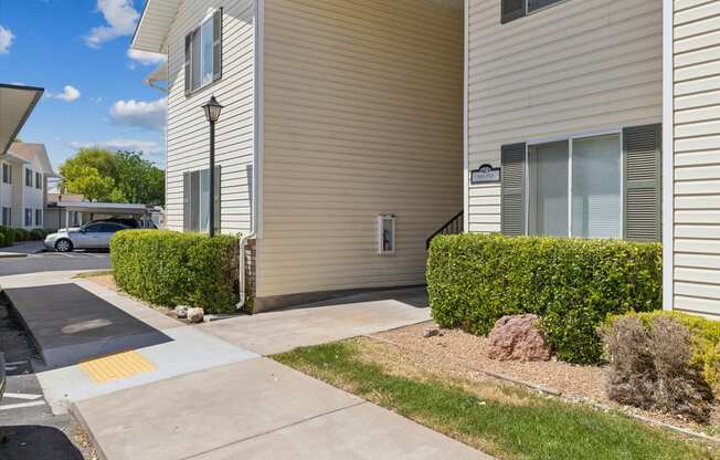 an apartment building with a sidewalk in front of it