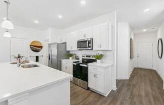 a white kitchen with white cabinets and stainless steel appliances