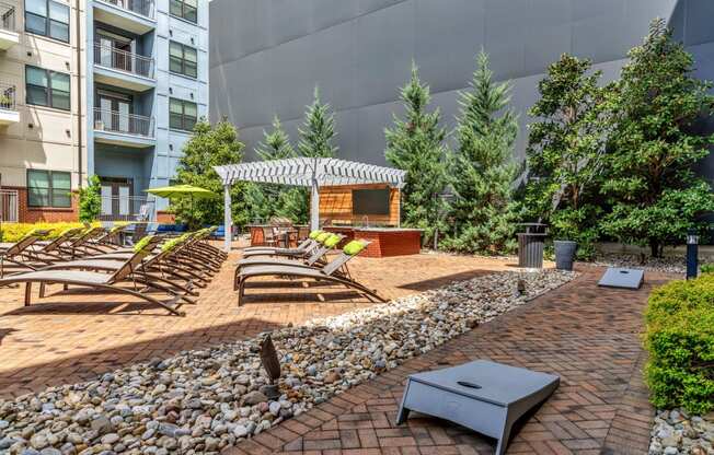 an outdoor lounge area with chairs and a fire pit