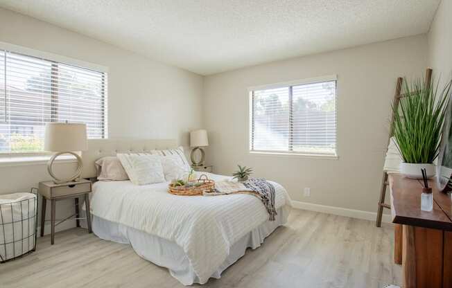 a bedroom with a bed and two windows