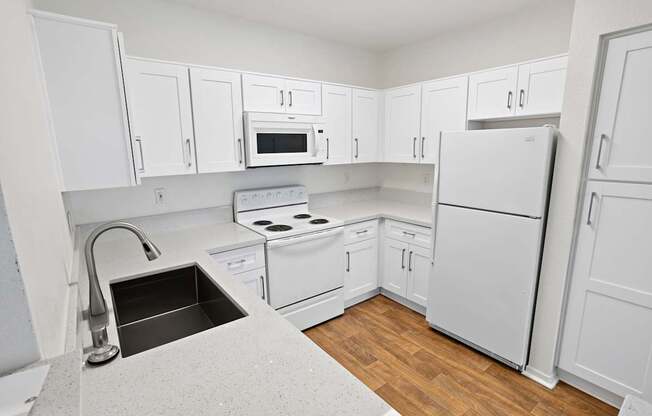 A kitchen with white cabinets and appliances.