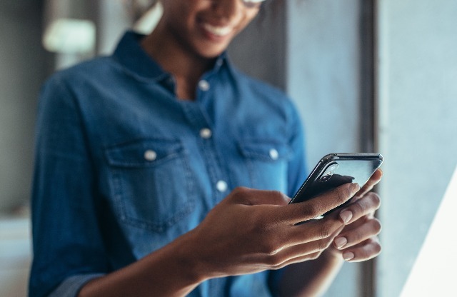 Woman in denim shirt looking at phone