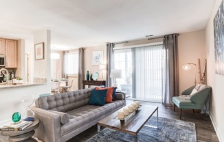 a living room with a gray couch and a coffee table in front of a sliding glass door