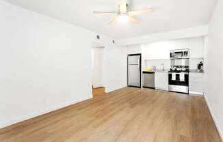 A kitchen with white walls and wooden floors.