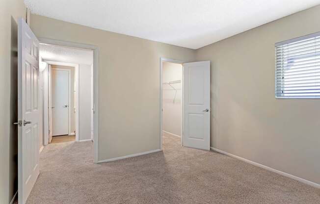 A room with carpeted floor and white doors.