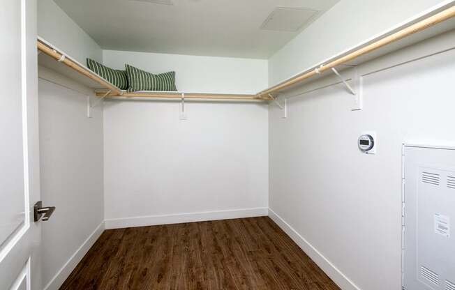 A small, empty room with a white door and a white electrical box on the wall.
