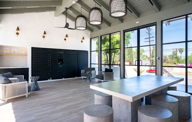 A modern dining area with a long table and concrete stools.