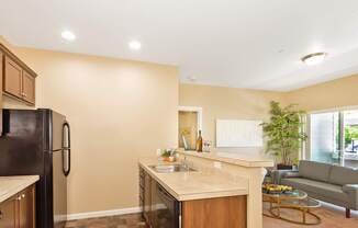 A kitchen with a black fridge and wooden cabinets at The Landing Apartments and Townhomes, Oregon, 97045
