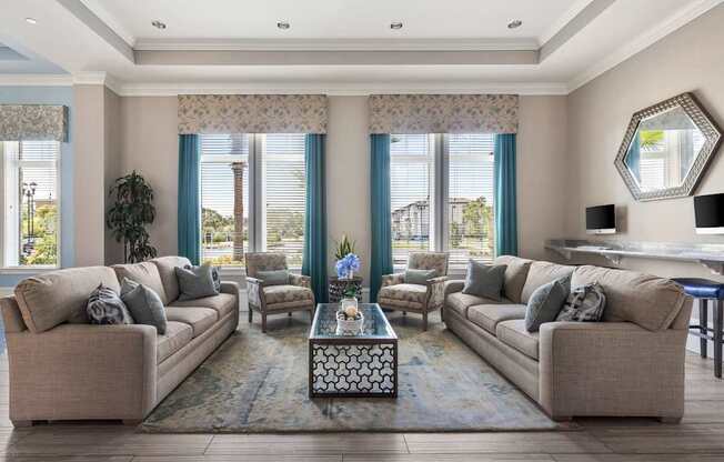 A living room with two couches, a coffee table, and a large window with blue curtains.
